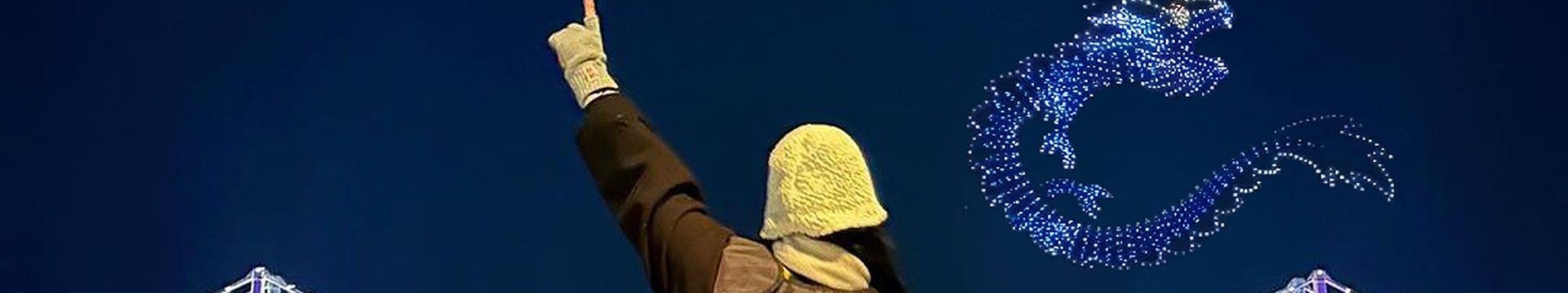 在船頭觀賞廣安大橋上空無人機燈光秀的乘客