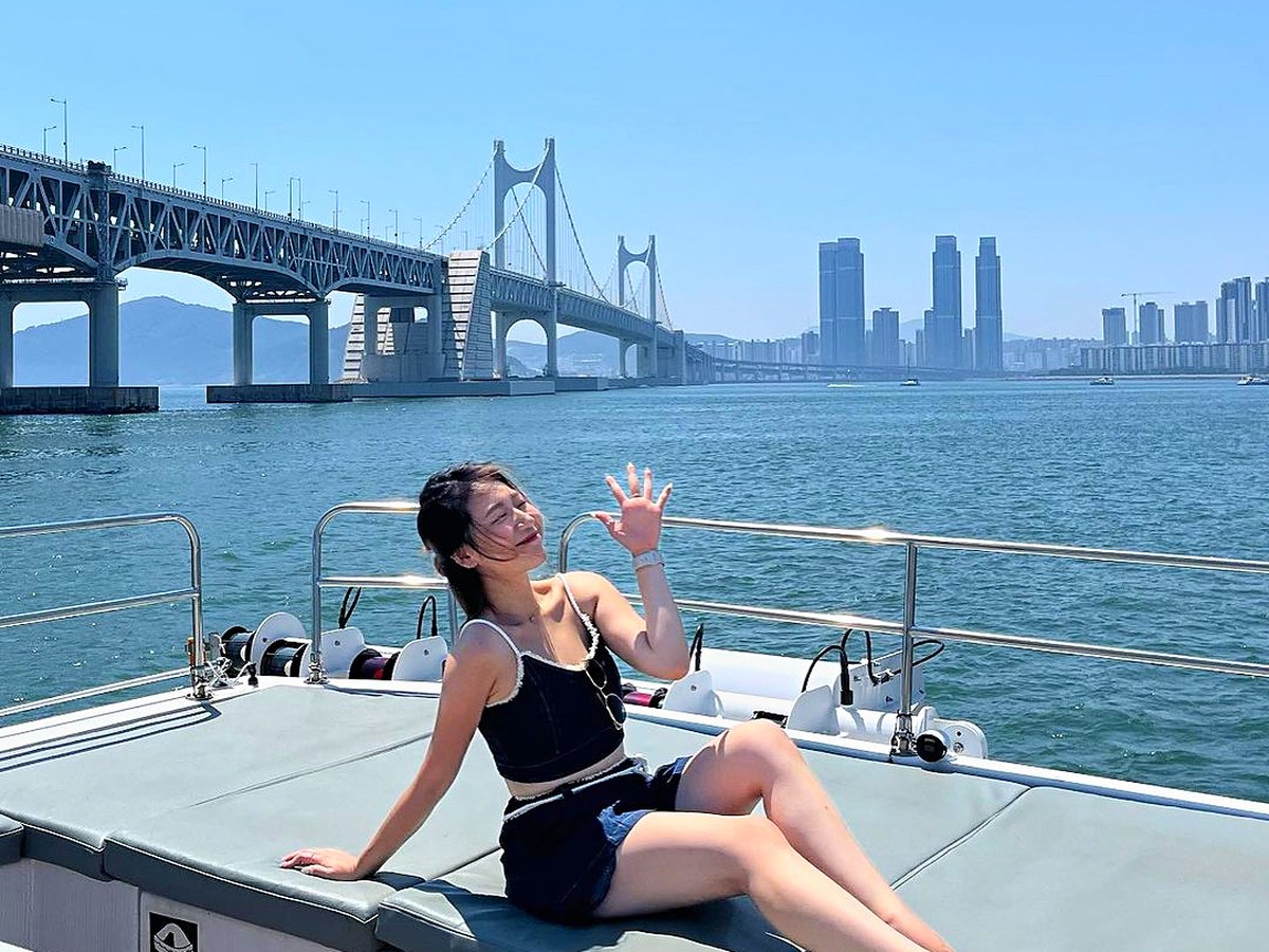 藍天下坐在甲板上的共乘遊船旅客