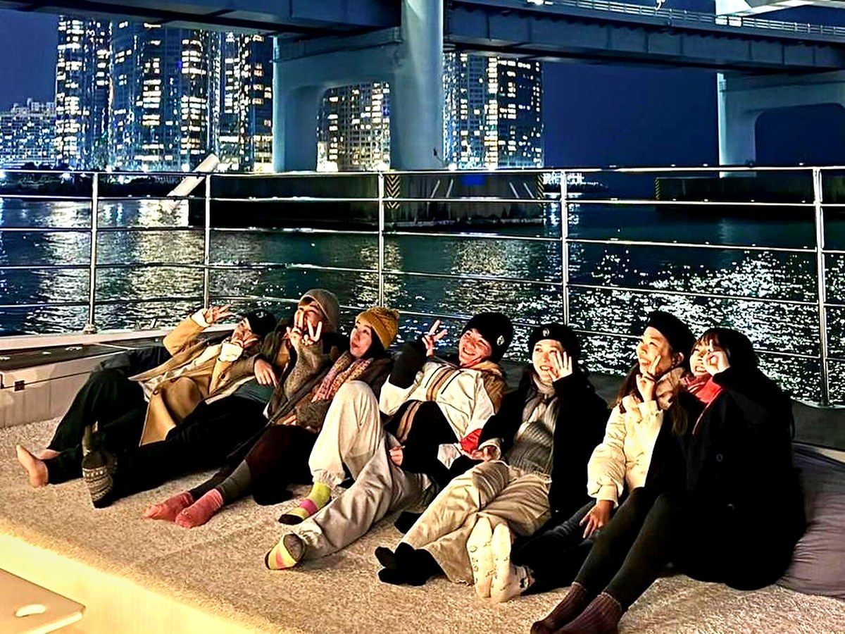 在點燈的廣安大橋前聚坐在甲板上的旅客